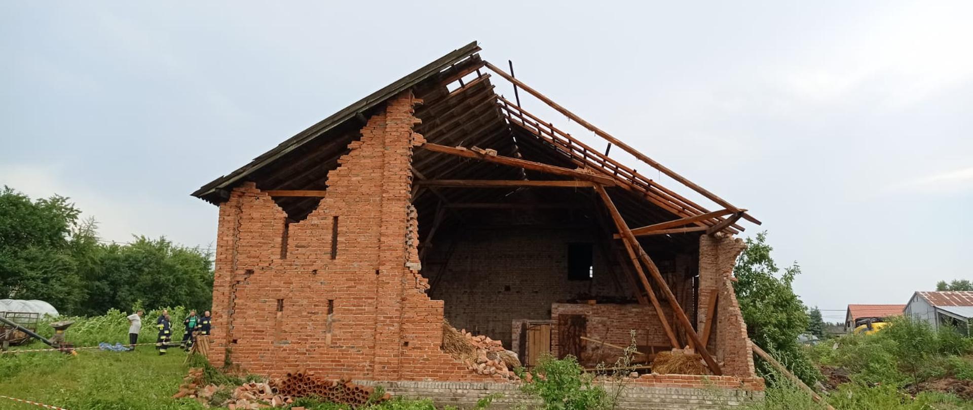 zawalenie się ściany szczytowej w murowanej stodole wykonanej z czerwonej cegły. 