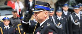 Powiatowe obchody Dnia Strażaka w Bielsku Podlaskim i Jubileusz 100-lecia OSP Rudka - komendant wojewódzki PSP oddaje honory, w tle strażacy stoją w szeregu