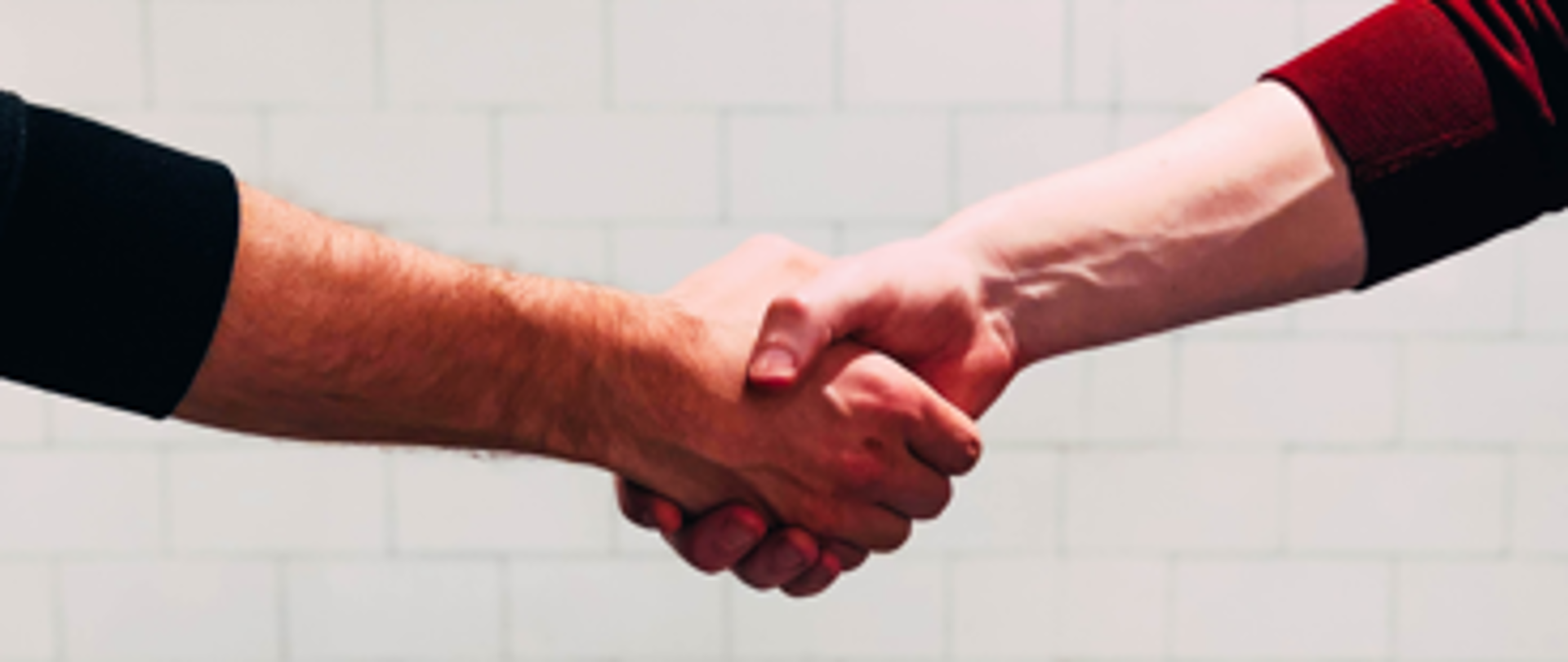 Dwie osoby witające się przez uścisk dłoni