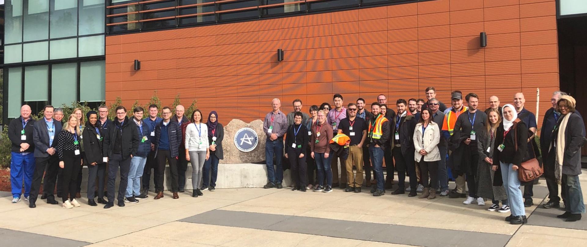 Uczestnicy konferencji nt. odpadów radioaktywnych podczas wizyty w laboratoriach Chalk River. Uczestnicy stoją przed siedzibą ośrodka badawczego