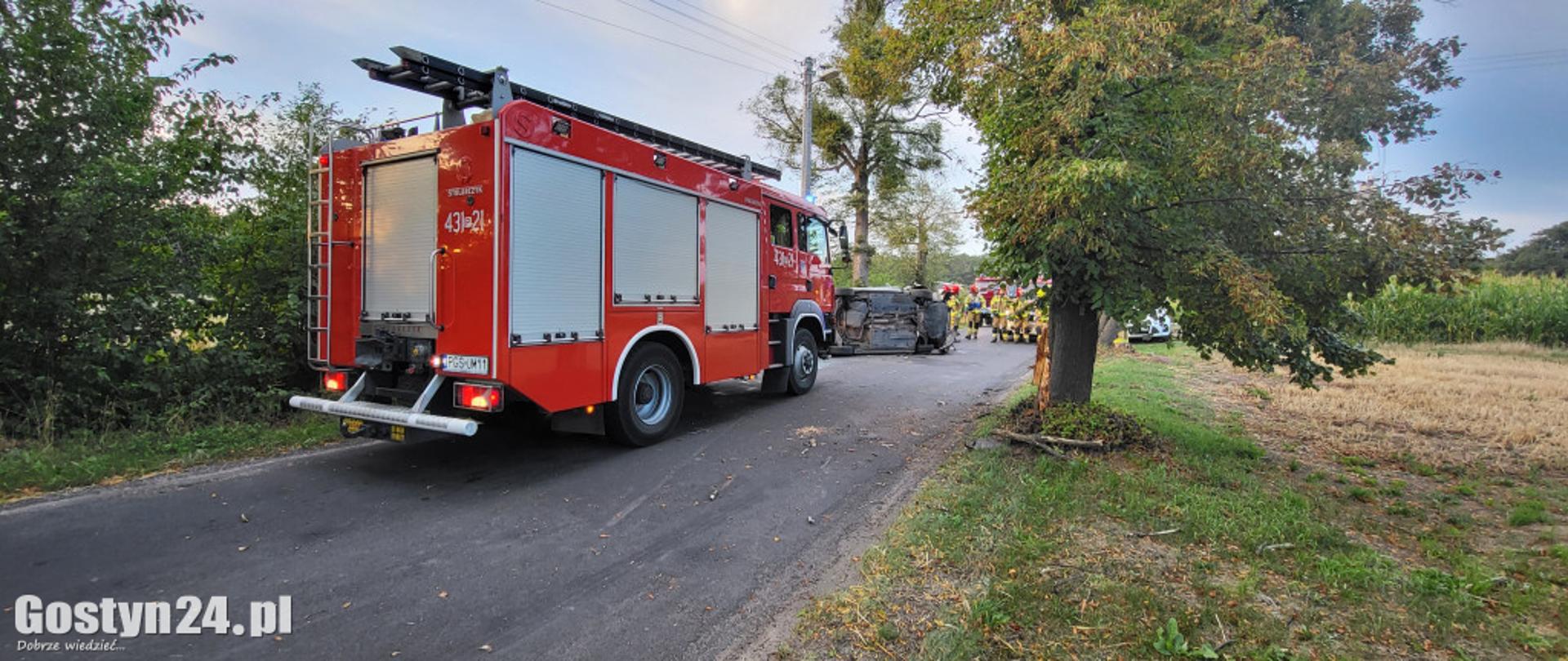 Zdjęcie przedstawia pojazd pożarniczy stojący na drodze.