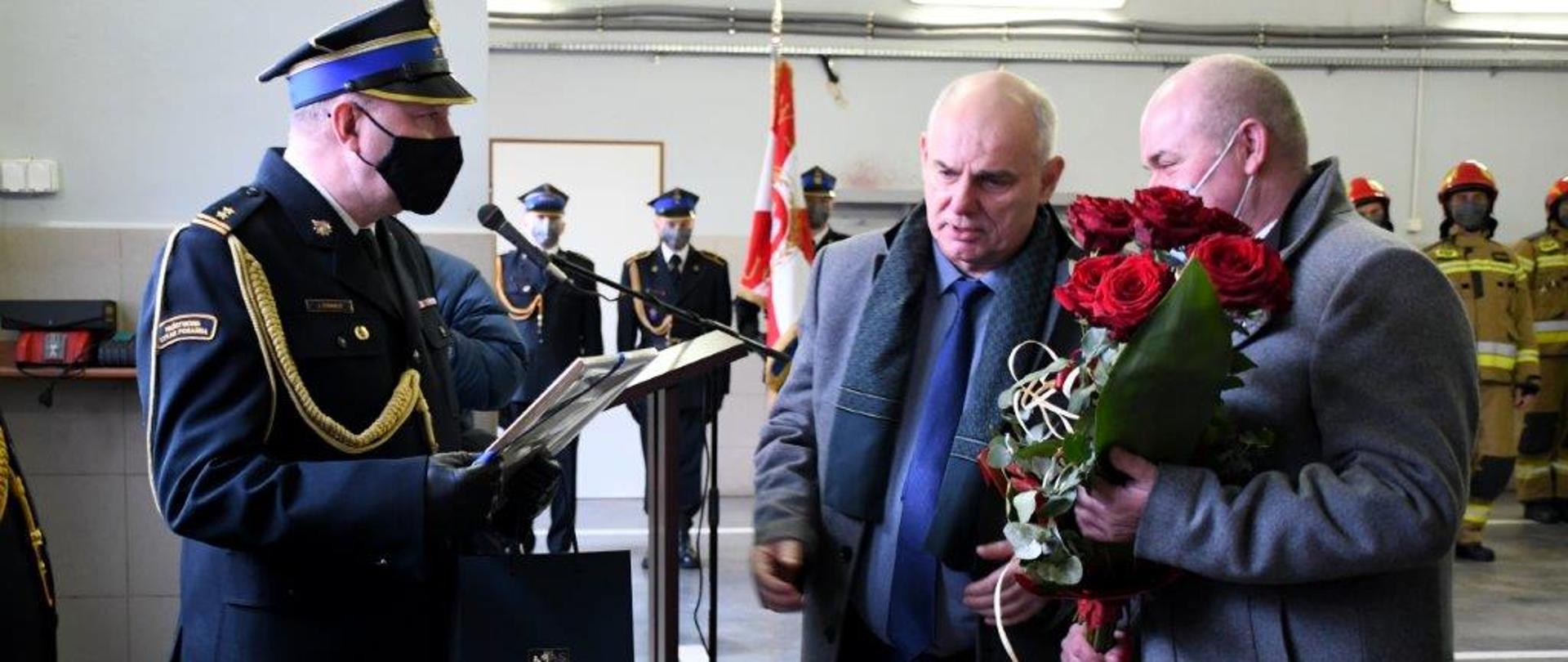 Na zdjęciu bryg. Stokwisz i żegnający go współpracownicy, goście. W podzięce przyjmuje kwiaty i gratulacje. W tle załoga. Rzecz dzieje się w garażu.