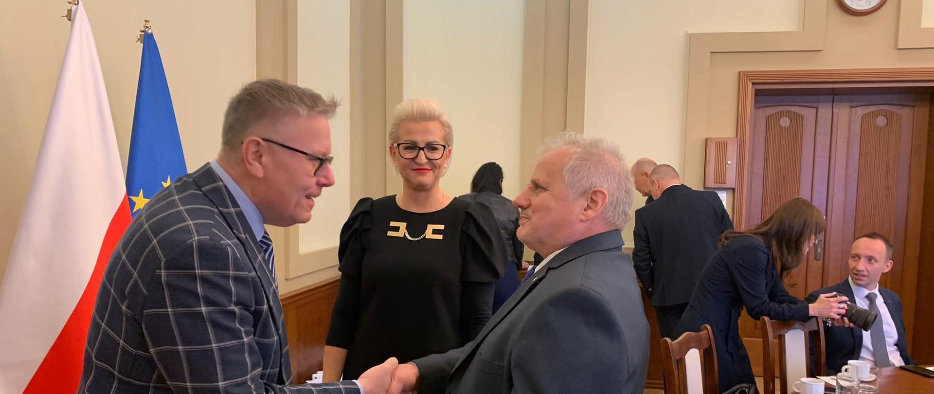 Zdjęcie przedstawia dwóch mężczyzn składających gratulacje