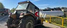 Na zdjęciu widać ciągnik rolniczy Ursus, uszkodzony, wokół rozlany olej hydrauliczny. W tle widać samochód strażacki. 