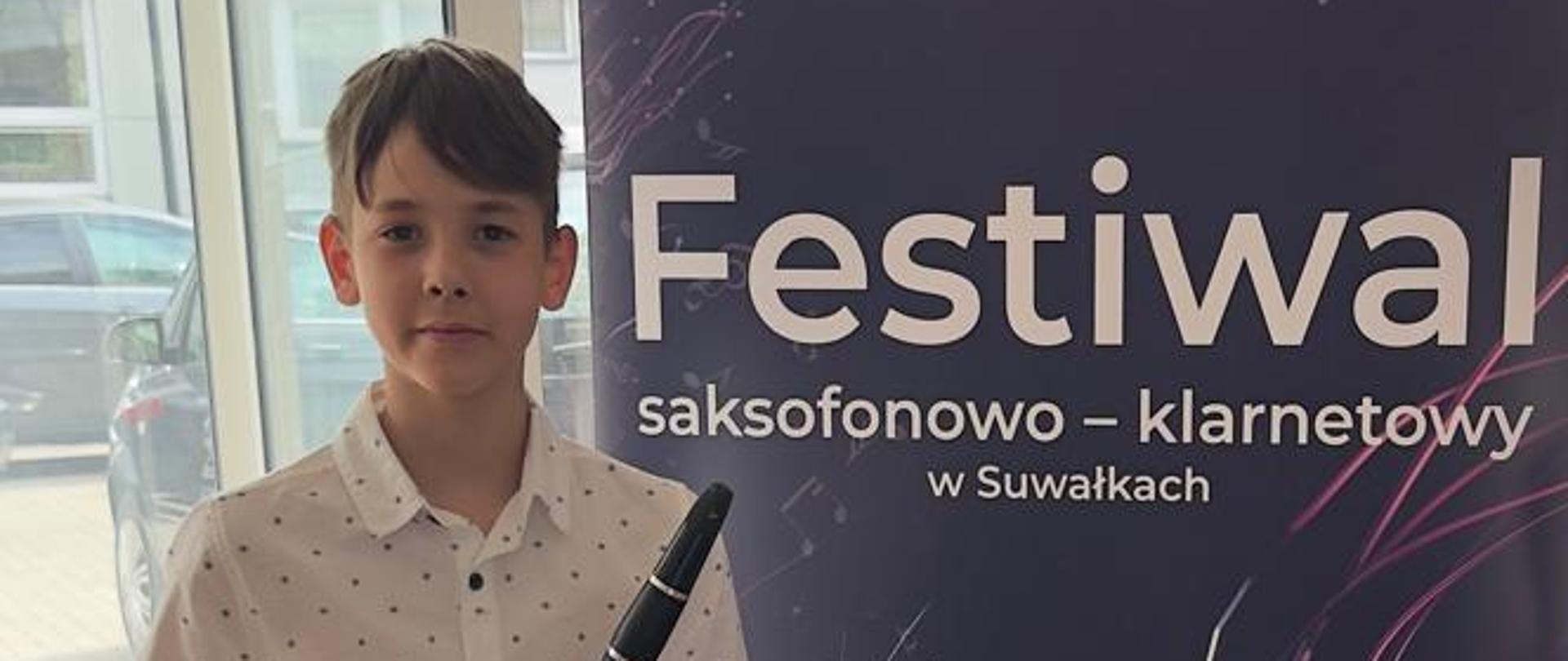 Kuba Pawłowski i Konrad Pankiewicz przy plakacie, trzymają klarnety