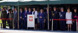 Zdjęcie zrobione na placu podczas uroczystości wojewódzkich obchodów Święta Wojska Polskiego w Rzeszowie. Uczestniczy uroczystości stoją pod zadaszeniem.