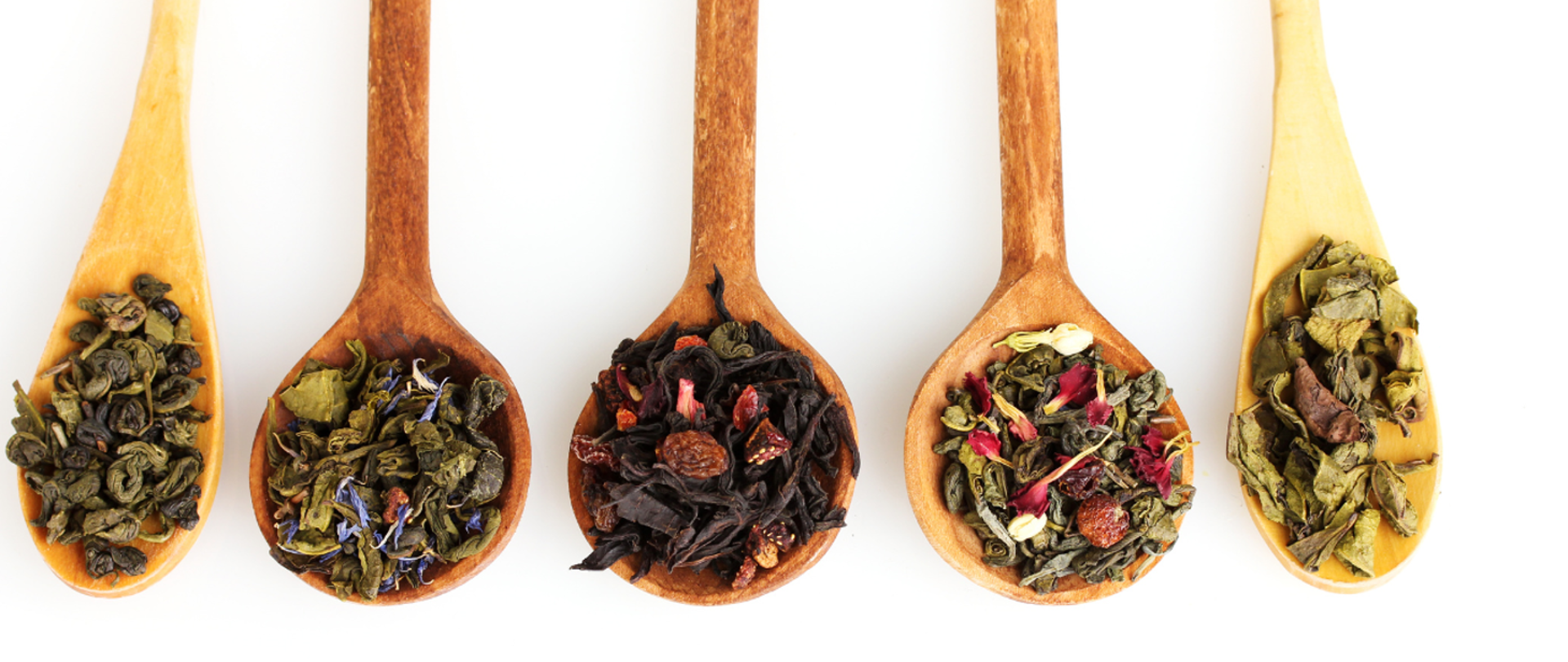 różne rodzaje herbaty na drewnianych łyżeczkach
