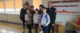 Na zdjęciu laureaci eliminacji w grupie szkół podstawowych klasy I-IV wraz z opiekunami oraz komendantem powiatowym PSP w Busku-Zdroju i jego zastępcą.