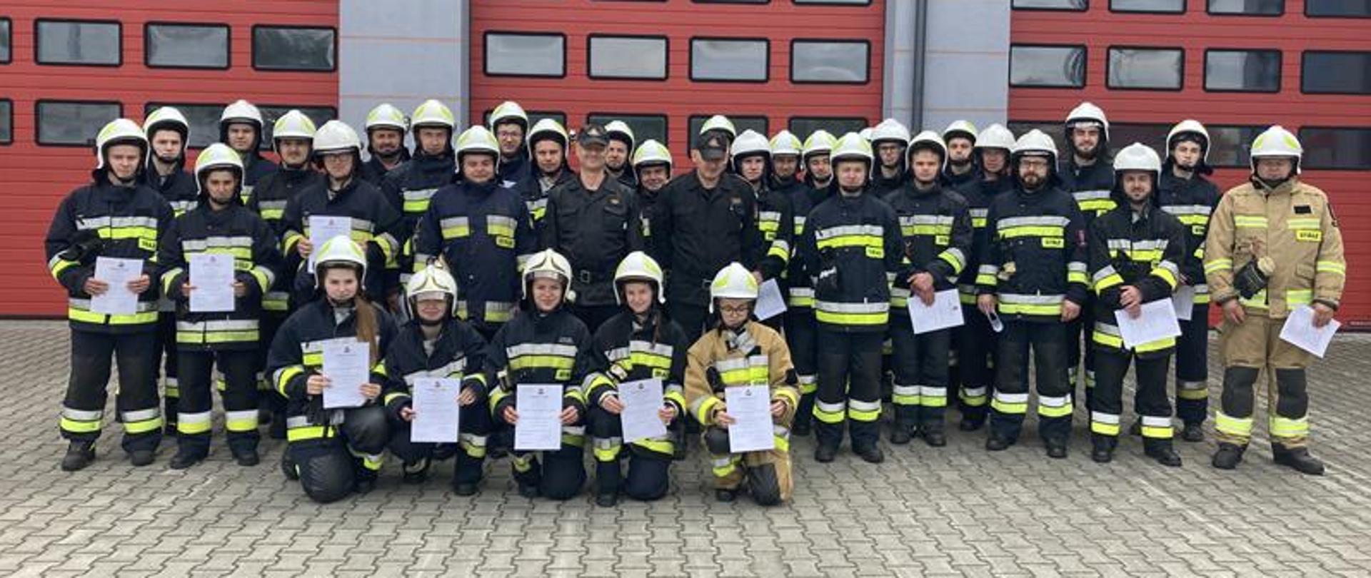 Uczestnicy kursu podstawowego po ukończonym szkoleniu wykonują sobie pamiątkowe zdjęcia ze świadectwami potwierdzającymi zdanie egzaminu.