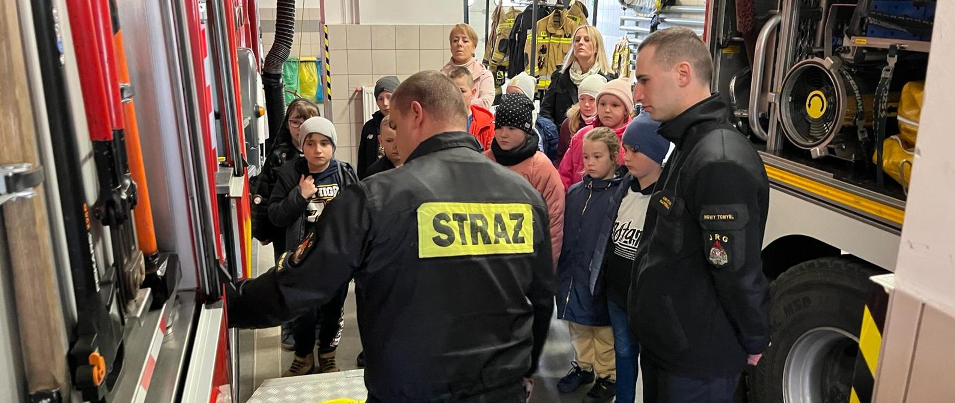 Strażacy opowiadający dzieciom o sprzęcie pożarniczym