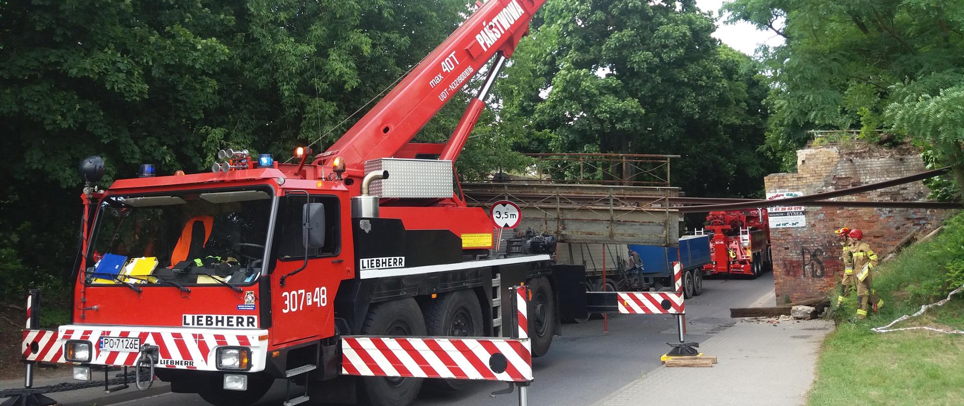Zdjęcie przedstawia pracę dźwigu - pojazdu strażackiego.