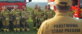 Strażacy stojący w dwuszeregu podczas odprawy przed ćwiczeniami.