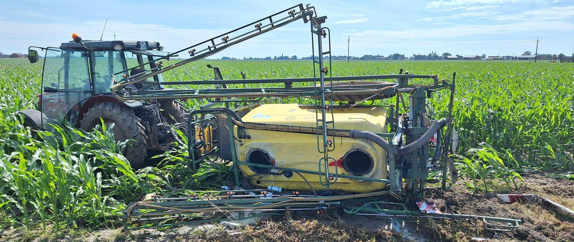 Ciągnik rolniczy z przewróconym opryskiwaczem 