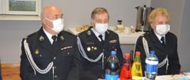 Zjazd OP ZOSP RP w Rawiczu. Sala wiejska w Rogożewie. Za stołem zasiada trzech strażaków w mundurach wyjściowych: jedna kobieta i dwóch mężczyzn.Na twarzach mają maseczki ochronne. Na stole znajdują się kubki i napoje.