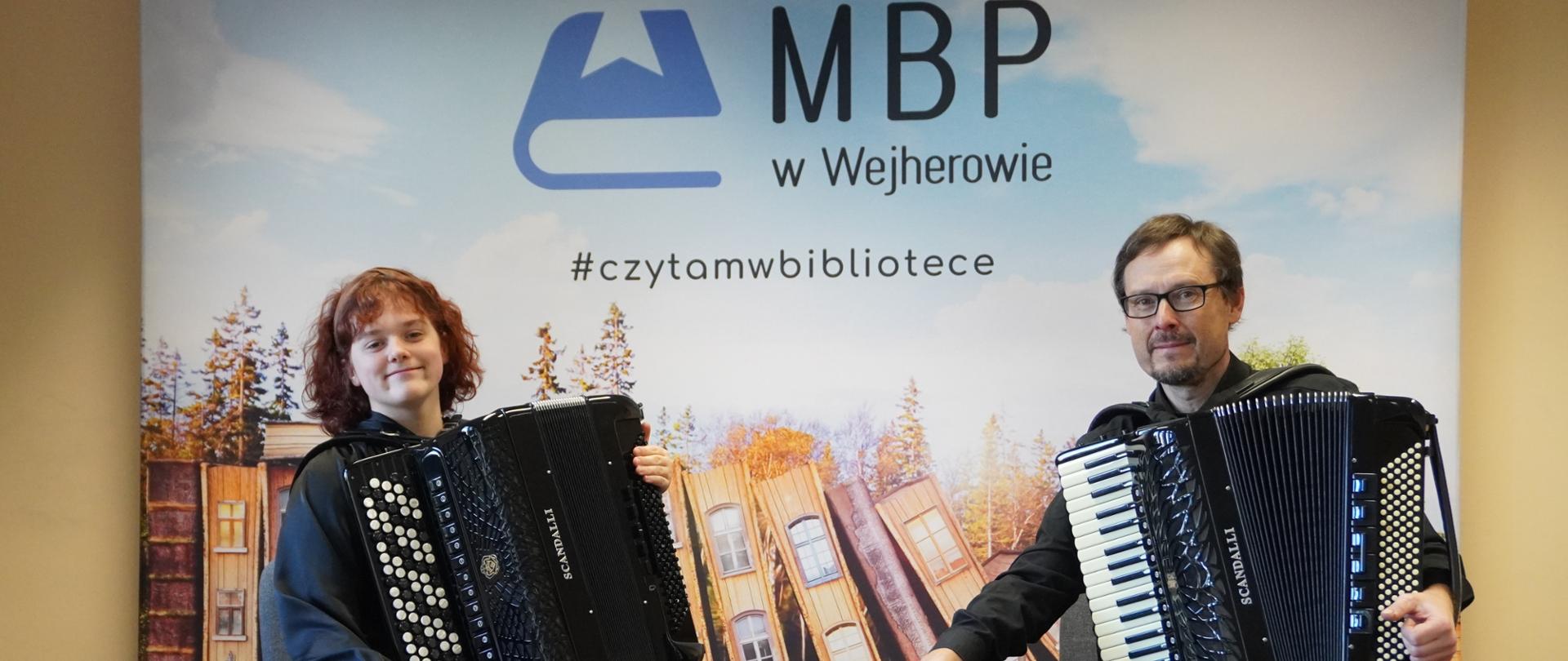 Zofia Dzienisz i Ryszard Borysionek pozują z akordeonami na estradzie wejherowskiej biblioteki