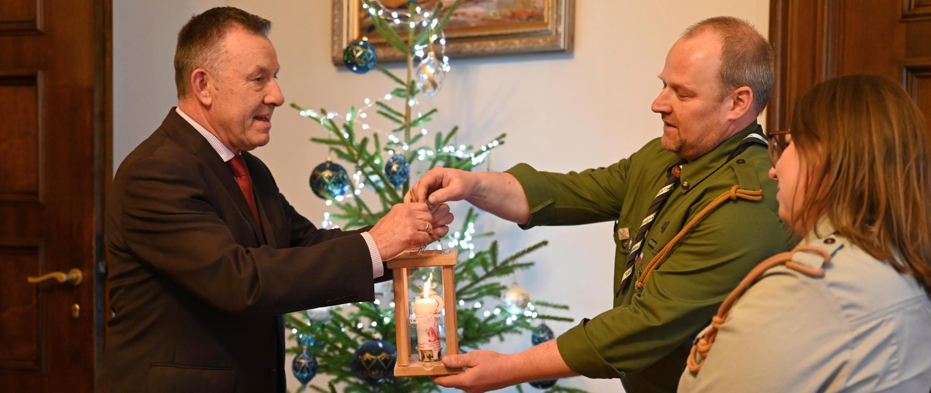 Wojewoda Łódzki Karol Młynarczyk odbiera światełko od harcerzy. 