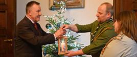 Wojewoda Łódzki Karol Młynarczyk odbiera światełko od harcerzy. 