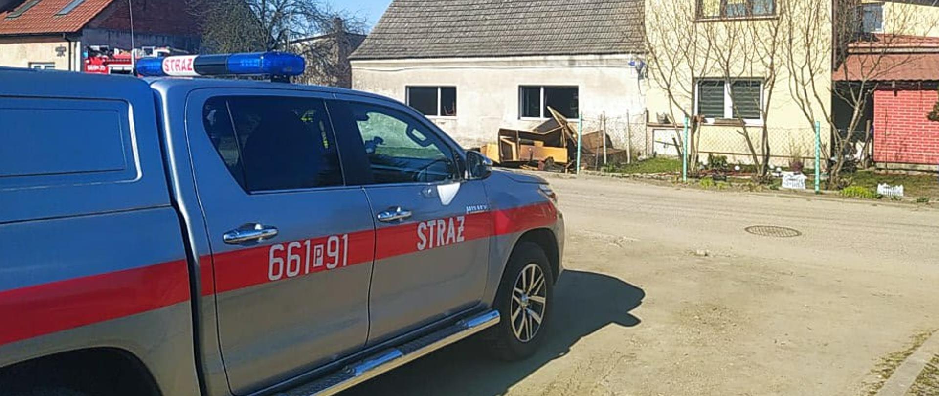 Na zdjęciu widzimy samochód operacyjny straży pożarnej oraz w tle budynek w którym był pożar.