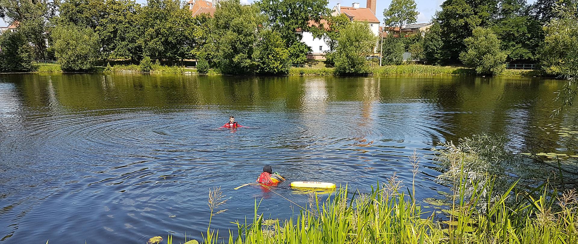 Zdjęcie przedstawia akcje ratowniczą polegającą na wydobyciu osoby tonącej z akwenu