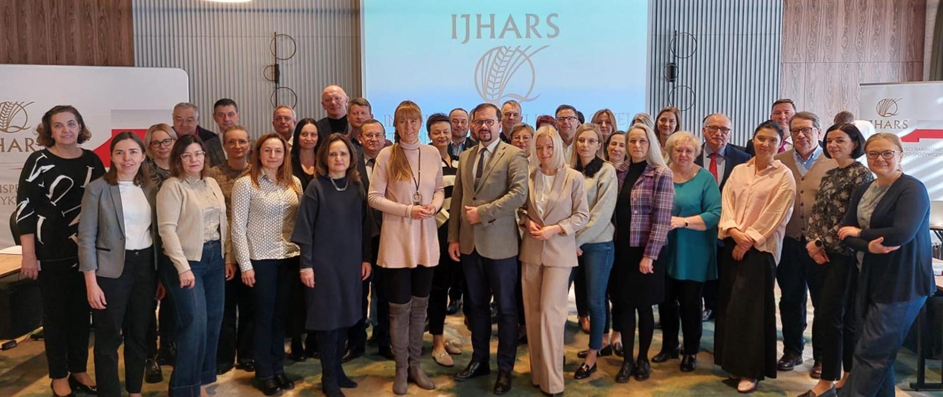 Grupa osób w tle logo IJHARS