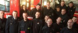 Zdjęcie pamiątkowe strażaków przy samochodzie pożarniczym