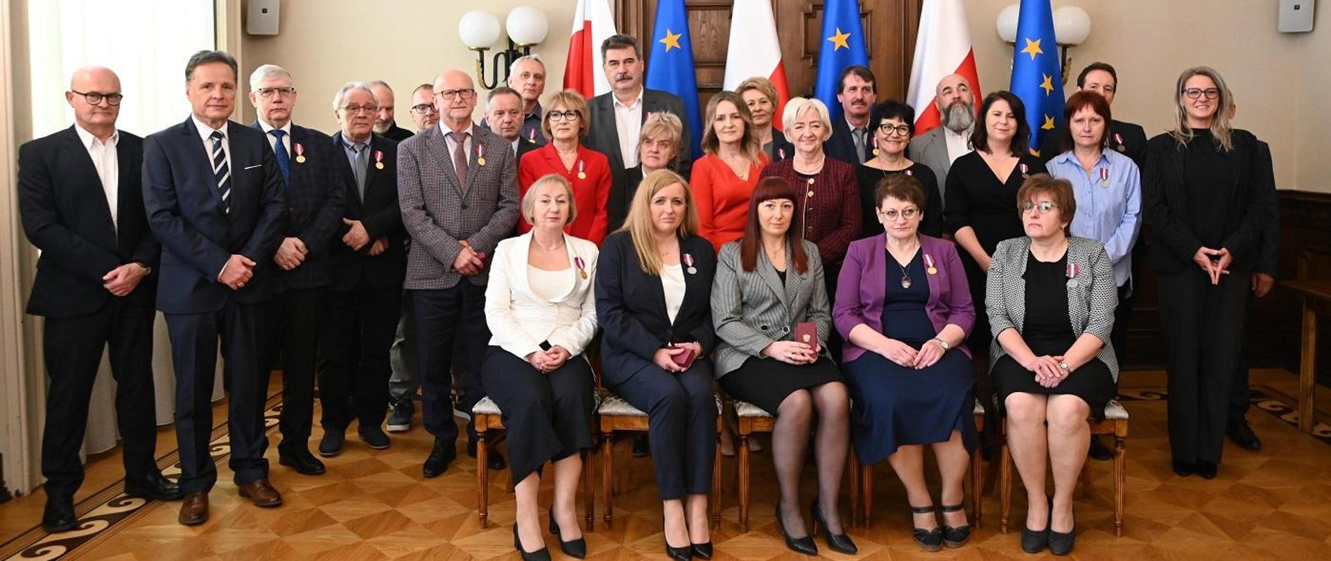 Pamiątkowa fotografia wojewody łódzkiego Doroty Ryl z pracownikami, którzy otrzymali Medale za Długoletnią Służbę. 