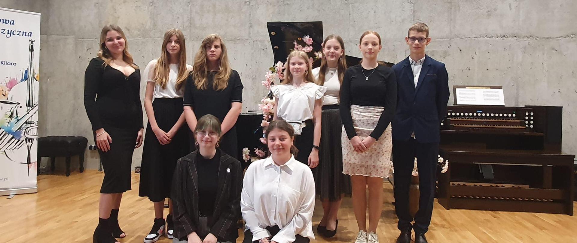 Grupa uczniów na scenie sali koncertowej