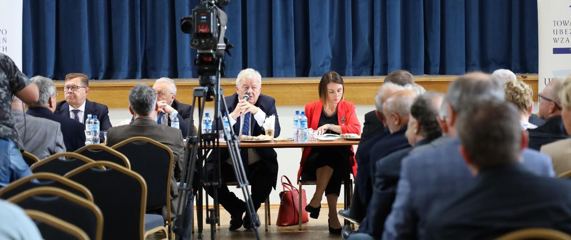 duża sala w niej kilkanaście osób, za stołem prezydialnym minister i wojewoda