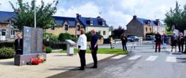 Un homme et une femme posent devant une plaque commémorative.