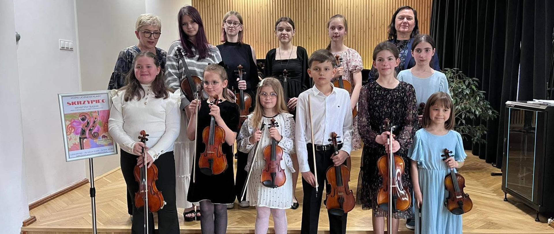 Galeria zdjęć z koncertu uczniów klas skrzypiec, który odbył się 26 maja w auli Państwowej Szkoły Muzycznej w Kłodzku. Na fotografiach uchwycono młodych wykonawców podczas występów oraz atmosferę wydarzenia, które zgromadziło rodziny, nauczycieli i miłośników muzyki.
