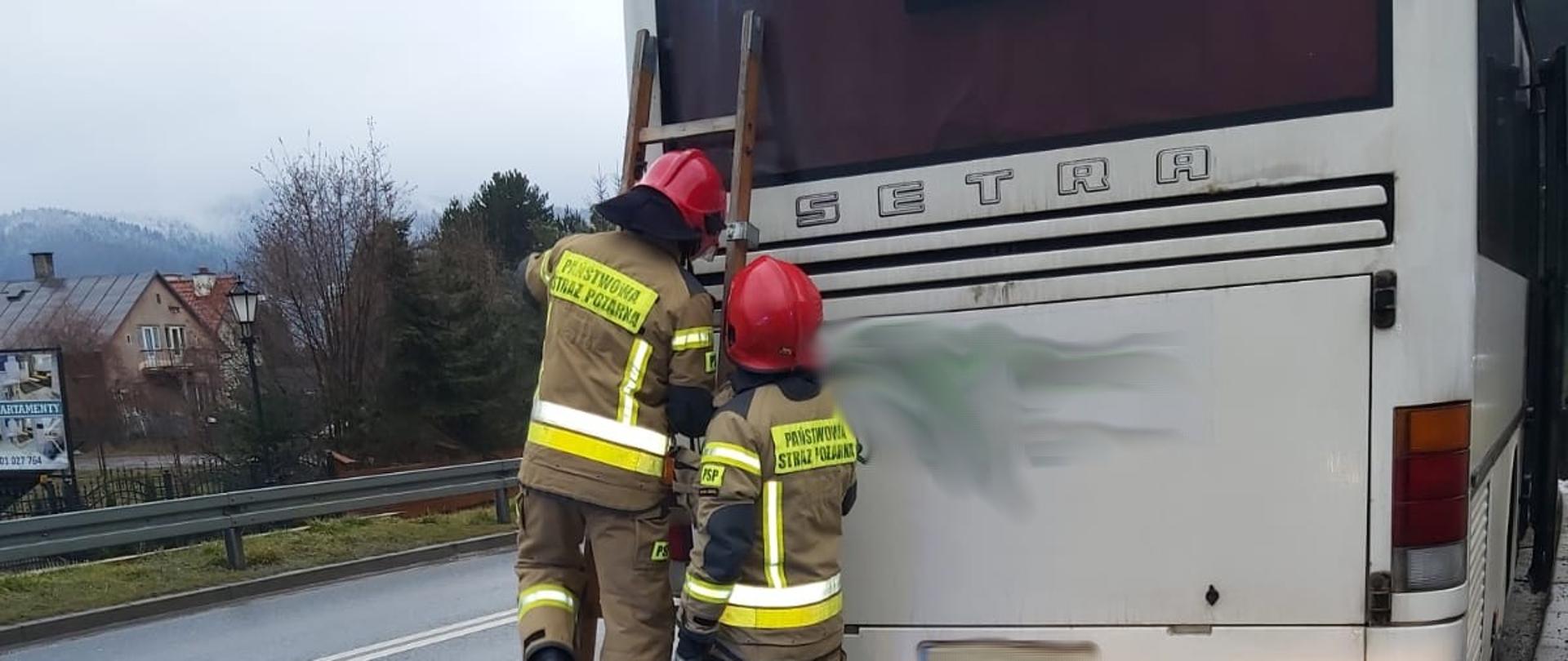 Strażacy i drabina przystawiona do autobusu