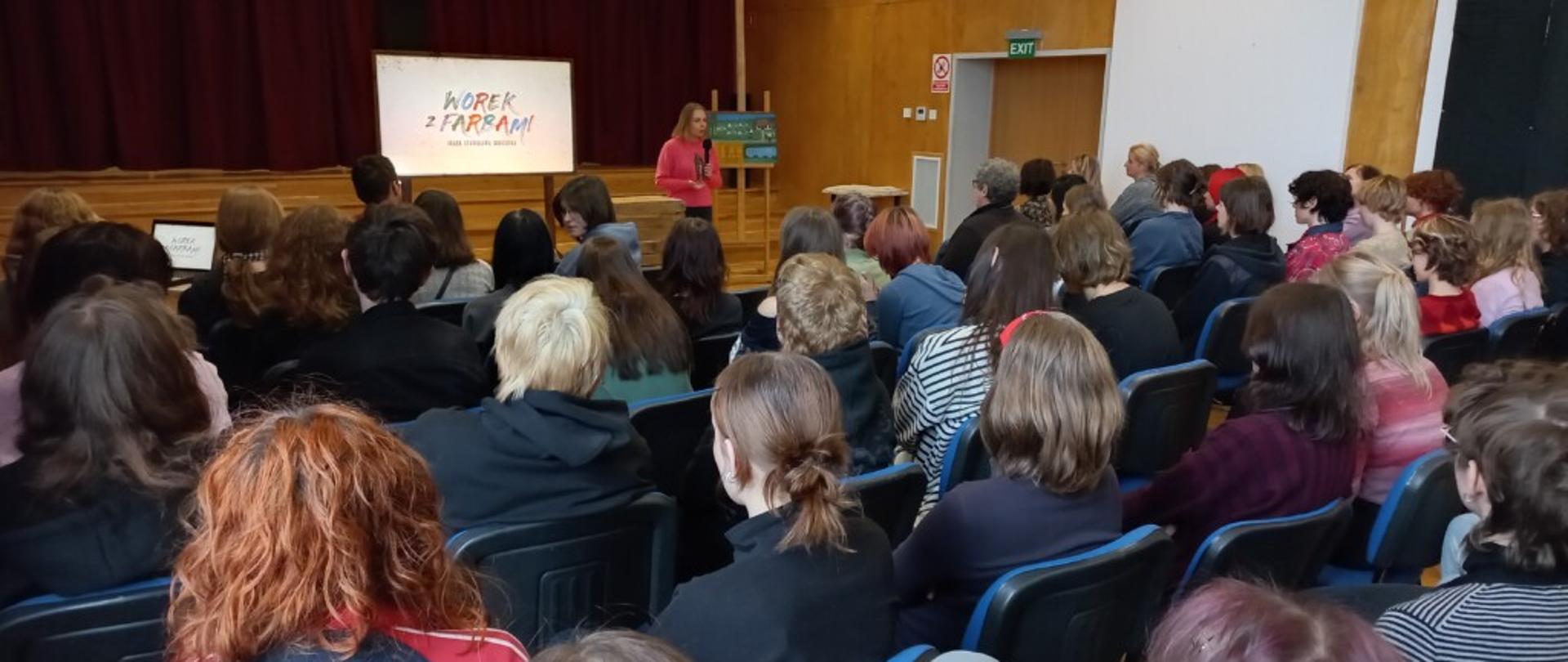 Fotografia grupy młodzieży w czasie wykładu w szkolnej auli