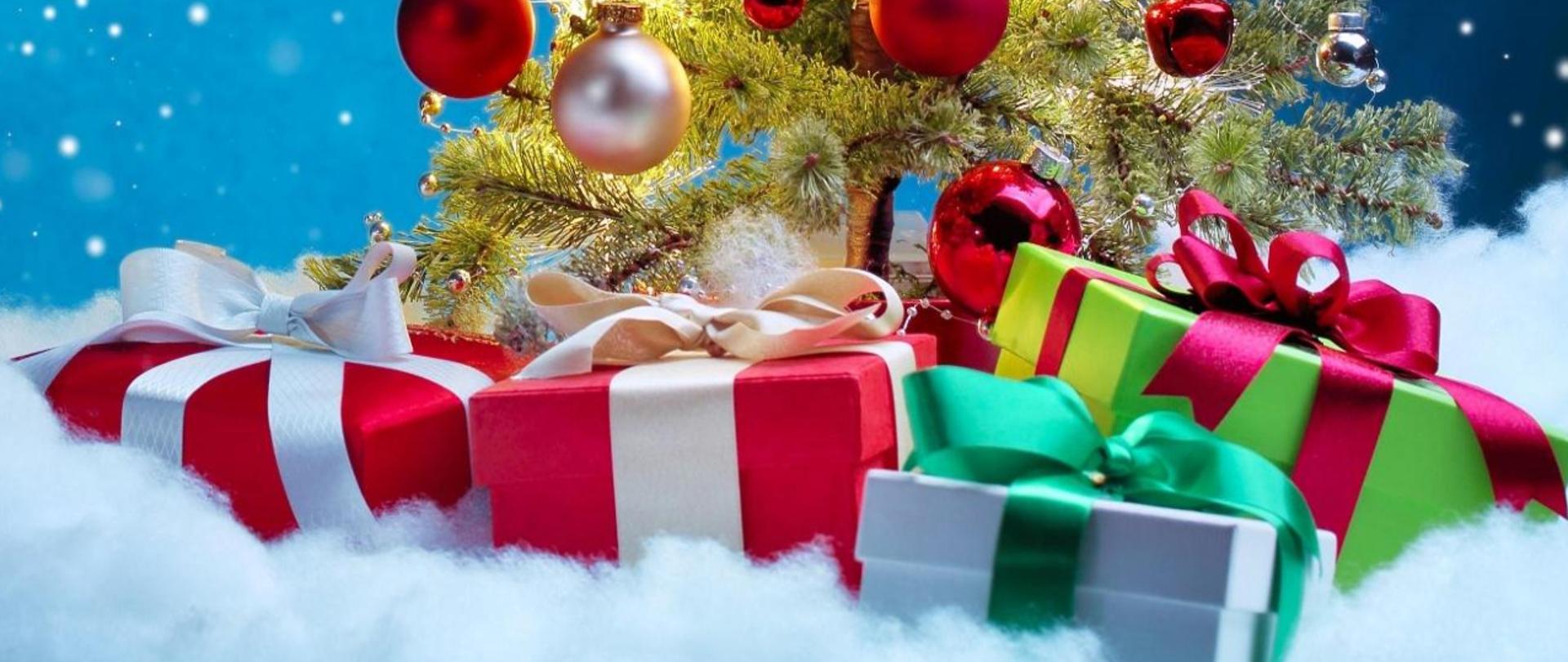 Padający śnieg na niebieskim tle. Z prawej strony choinka, pod nią prezenty. Po lewej życzenia świąteczne o treści Z okazji zbliżających się Świąt Bożego Narodzenia życzymy by tegoroczne święta były pełne ciepła, uśmiechu i magicznej atmosfery. Świąt spędzonych w gronie bliskich osób, a także dużo pozytywnej energii i radości na nadchodzący Nowy 2026 Rok życzy Dyrektor i cała społeczność Państwowej Szkoły Muzycznej I st. im. Karola Namysłowskiego w Szczebrzeszynie