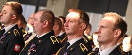Strażacy stoją w szyku z otrzymanymi odznaczeniami