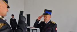 Zdjęcie przedstawia Komendanta Powiatowego PSP w Lwówku Ślaskim oddającego honory funkcjonariuszowi odchodzącemu na emeryturę.