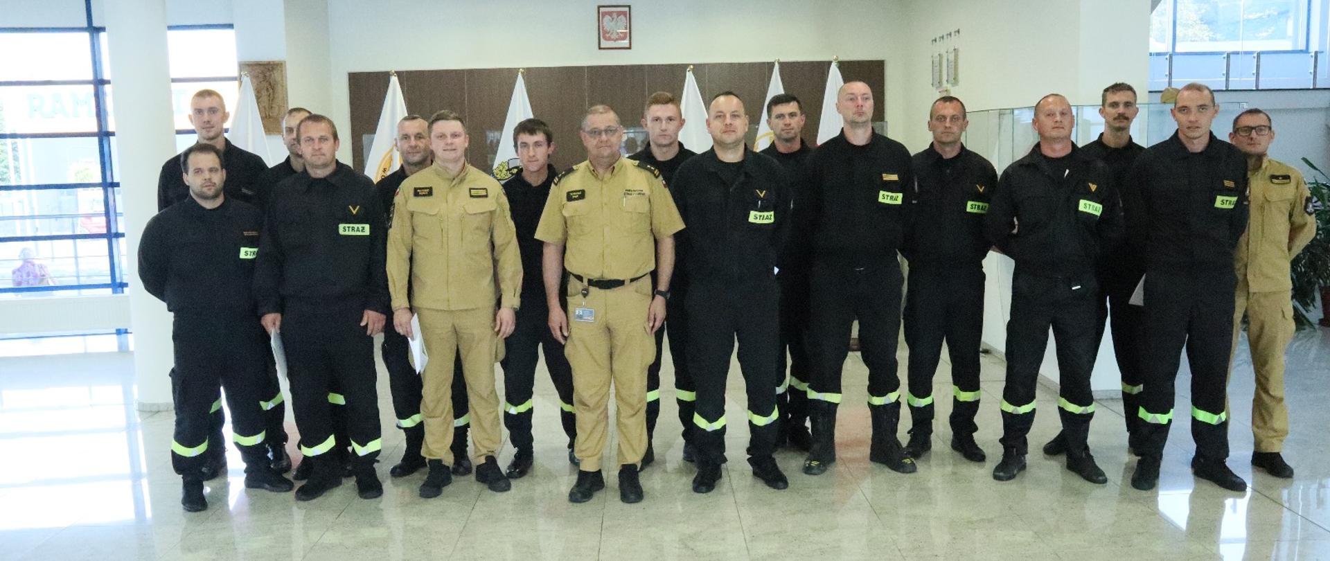 Grupowe zdjęcie uczestników szkolenia kierowców (14 funkcjonariuszy PSP) w towarzystwie Zastępcy Komendanta Centralnej Szkoły PSP oraz oficera CS PSP