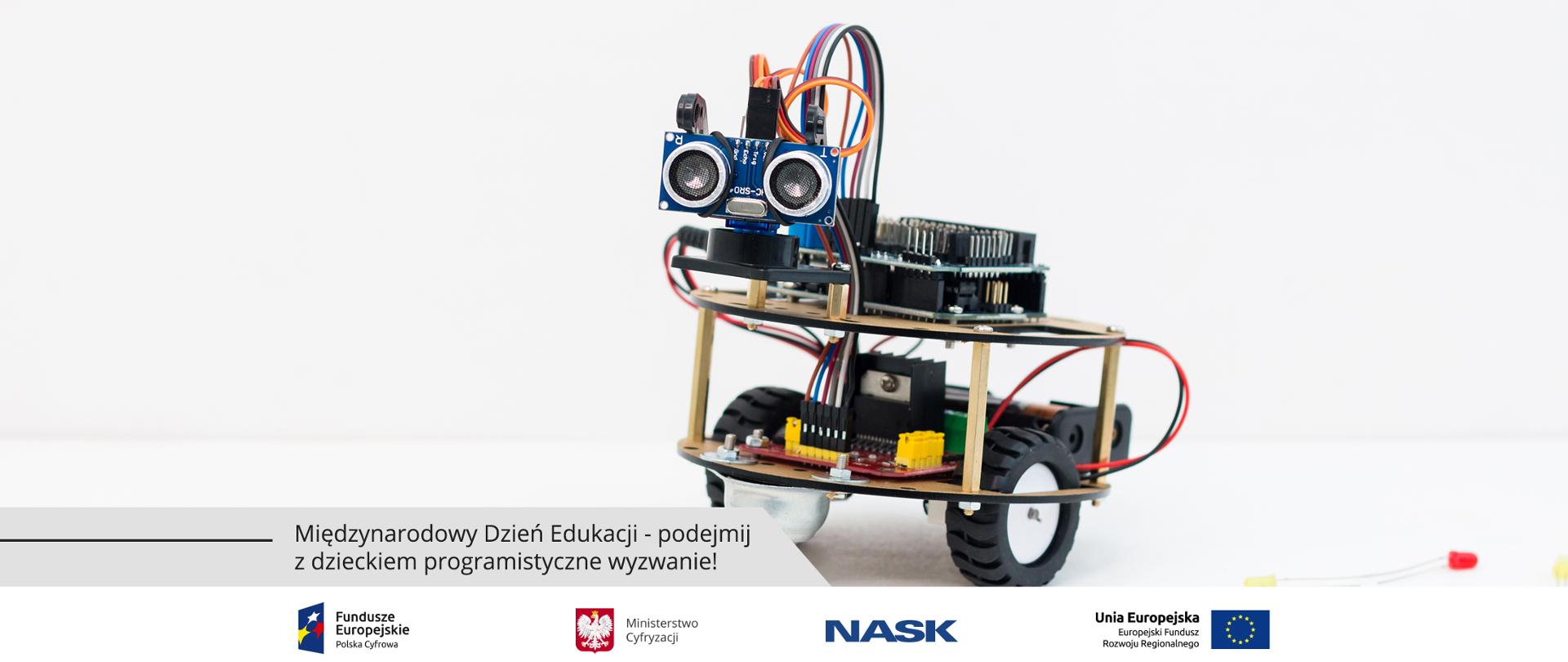 Grafika. Miniatura robota na dwóch kółkach. Poniżej napis: Międzynarodowy Dzień Edukacji - podejmij z dzieckiem programistyczne wyzwanie!