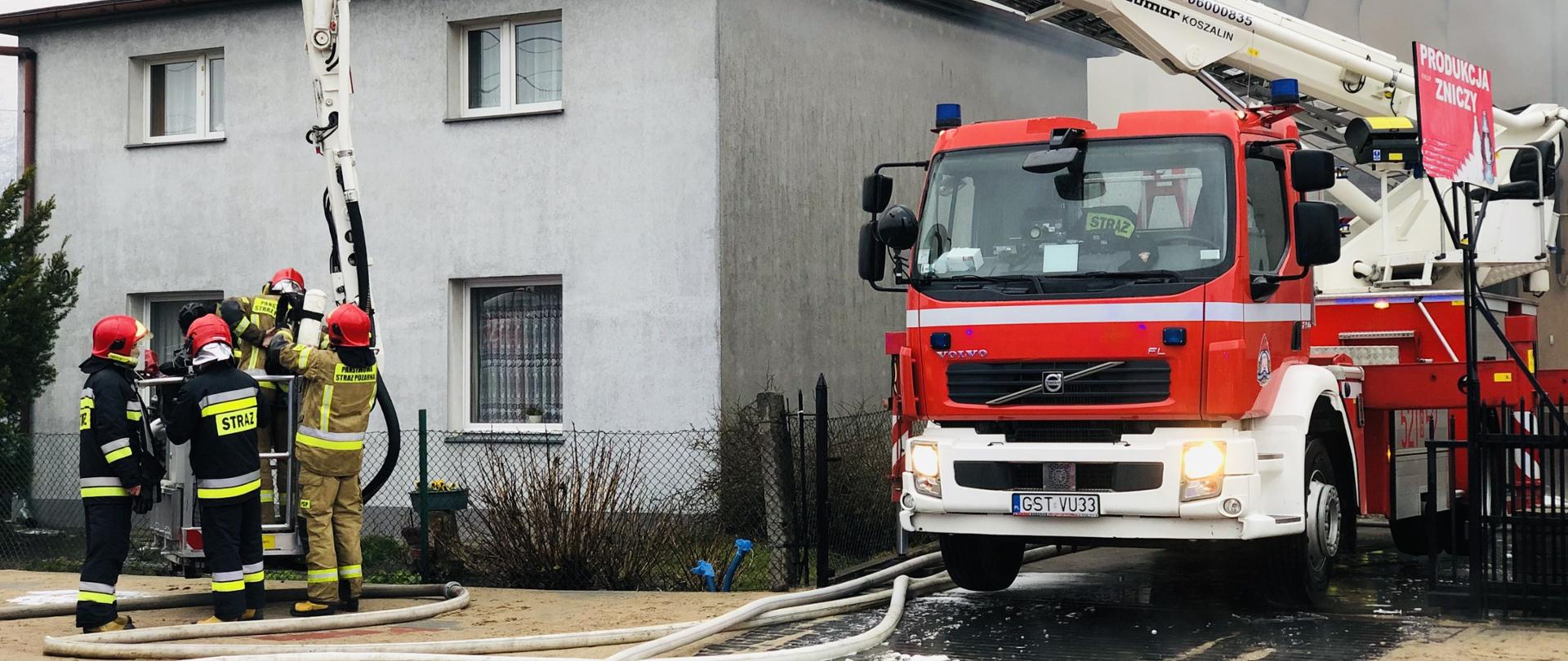 Na zdjęciu widać akcję ratowniczą, rozstawiona drabina , strażacy w koszu drabiny, na ziemi widać węże 