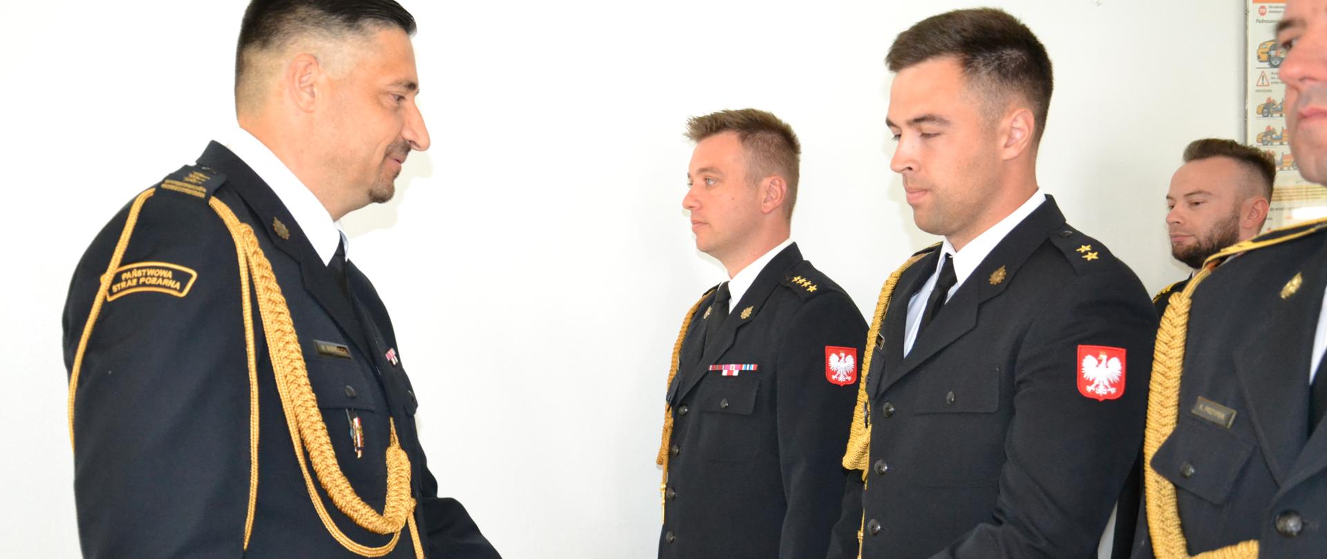 Komendant Powiatowy PSP w Ropczycach wręcza akt mianowania na wyższe stanowisko służbowe, strażacy w umundurowaniu galowym