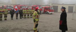 Zdjęcie przedstawia złożenie meldunku Komendantowi Powiatowemu PSP w Brodnicy st. bryg. Waldemarowi Szrull. W tle strażacy i samochody pożarnicze.