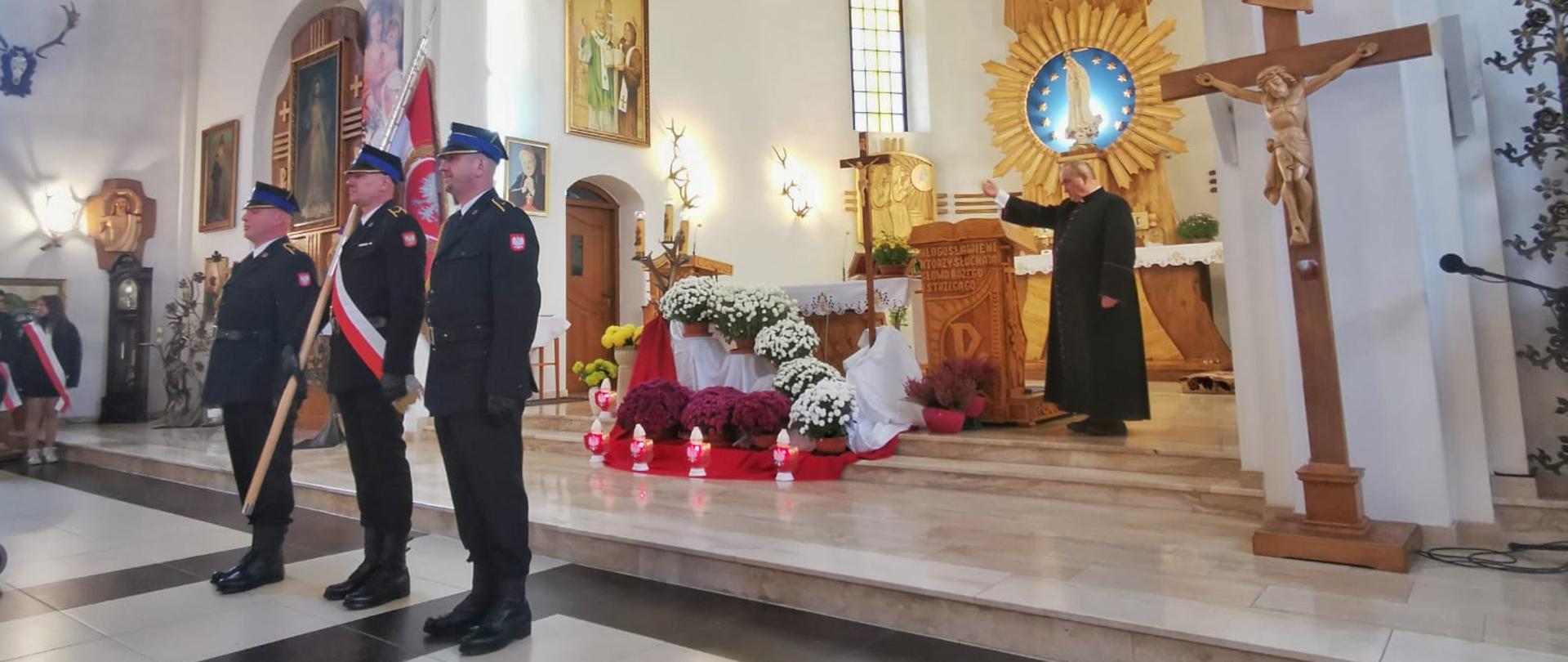 W kościele na środku przed ołtarzem stoi poczet sztandarowy.