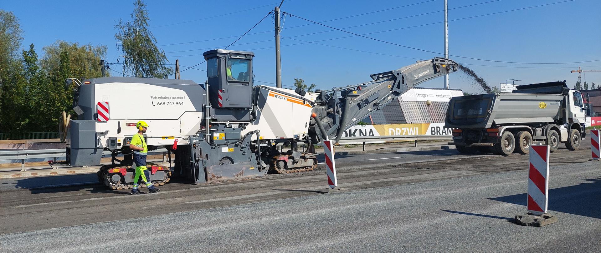 Na zdjęciu maszyny frezujące nawierzchnię drogową. Widać robotników.