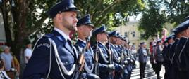 Policjanci uczestniczący w wydarzeniu stoją w szeregu. W rękach trzymają broń.