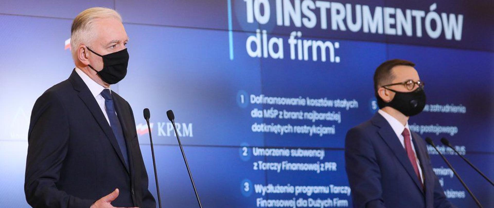 Od lewej: wicepremier Jarosław Gowin i premier Mateusz Morawiecki, w tle slajd z 10 instrumentami dla firm.
