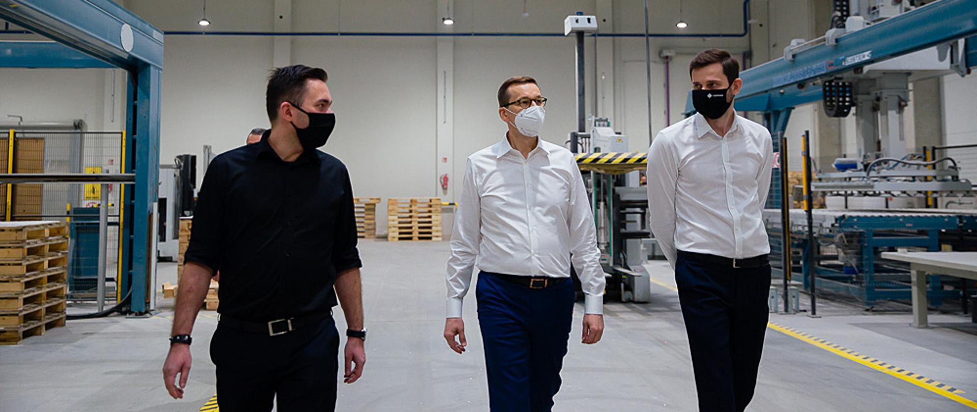 Premier oraz reprezentanci firmy idą po siedzibie.