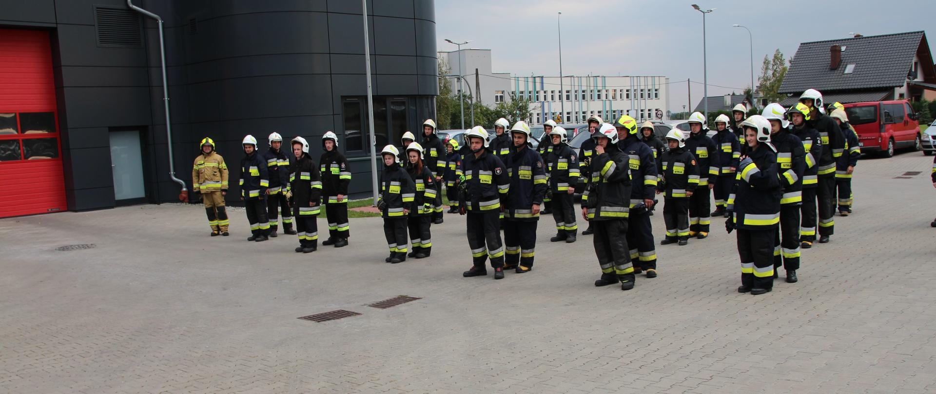 zdjęcie przedstawia zbiórkę strażaków którzy wezmą udział w szkolenie podstawowe strażaków ratowników Ochotniczych Straży Pożarnych