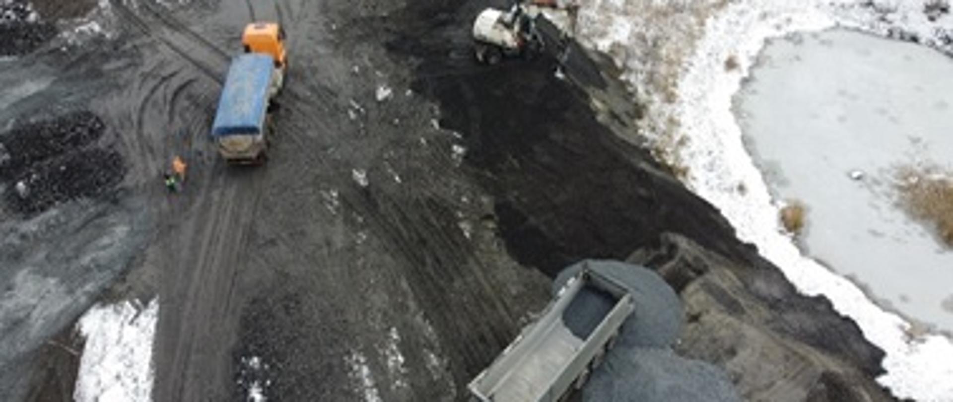 Składowisko odpadów. Na zdjęciu dwie ciężarówki przewożące odpady.