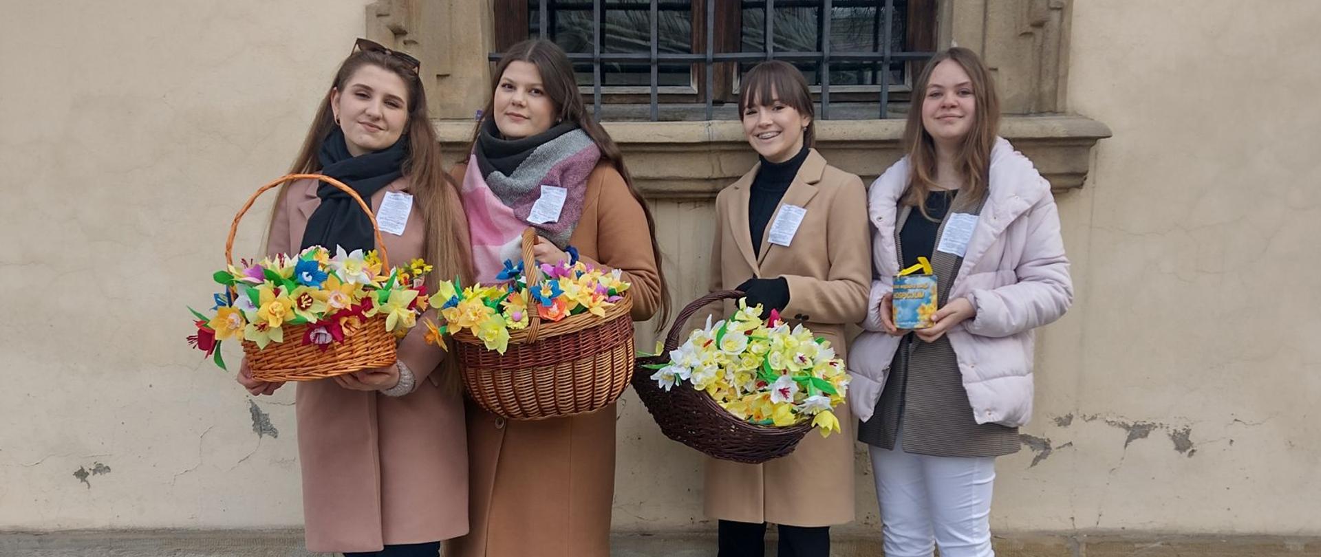Cztery uczestniczki akcji z koszami pełnymi kwiatów