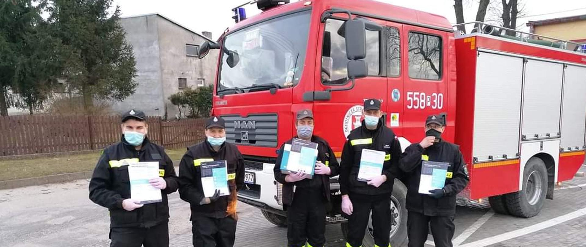 Na zdjęciu widać strażaków OSP podczas dystrybucji ulotek.