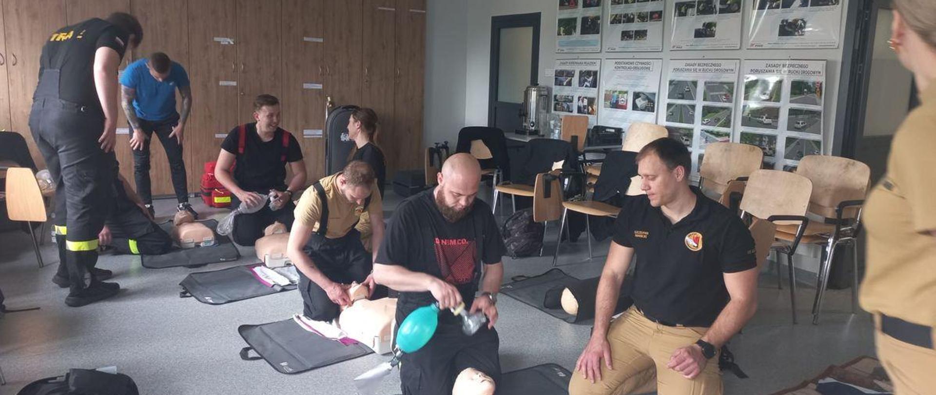 Druhowie jednostek ochotniczej straży pożarnej uczą się na manekinie resuscytacji krążeniowo-oddechowej. Strażacy uczą się na wielu stanowiskach przy czterech manekinach. Zajęcia prowadzone są na sali szkoleniowej Ośrodka Szkolenia Komendy Wojewódzkiej Państwowej Straży Pożarnej w Opolu.